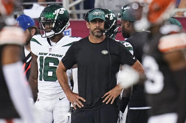 New York Jets quarterback Aaron Rodgers, center, stands on the sideline during the first half of the team's Hall of Fame NFL football preseason game against the Cleveland Browns, Thursday, Aug. 3, 2023, in Canton, Ohio. (AP Photo/Sue Ogrocki)