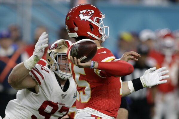 FILE - In this Feb. 2, 2020, file photo, Kansas City Chiefs quarterback Patrick Mahomes, right, passes under pressure from San Francisco 49ers' Nick Bosa, left, during the first half of the NFL Super Bowl 54 football game in Miami Gardens, Fla. The potential for a Bosa brothers reunion in the NFL will have to wait at least a few more years. Big brother Joey has signed a long-term extension with the Los Angeles Chargers and younger brother Nick has three years left on his rookie deal with the 49ers. So the pass rushing stars won’t be linking up on the same team anytime soon. (AP Photo/Chris O'Meara, File)