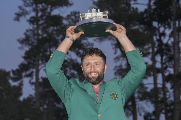 FILE - Jon Rahm, of Spain, holds up the trophy after winning the Masters golf tournament at Augusta National Golf Club on Sunday, April 9, 2023, in Augusta, Ga. (AP Photo/David J. Phillip, File)