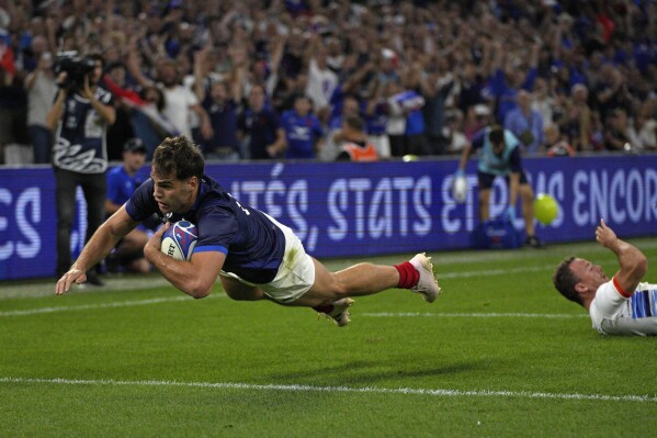 France's Damian Penaud dives over to score the his side's fourth try in the Rugby World Cup Pool A match between France and Namibia at the Stade de Marseille in Marseille, France, Thursday, Sept. 21, 2023. (AP Photo/Daniel Cole)