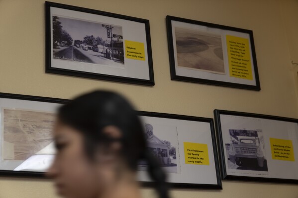 A waitress walks past historical images of Boardman, Ore., at Sunrise At Boardman cafe on Friday, Aug. 23, 2024, in Boardman. (AP Photo/Jenny Kane)