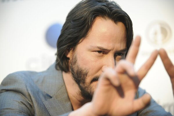FILE - In this May 2, 2013 file photo, Keanu Reeves arrives at the LA premiere of "Generation Um..." in Los Angeles. On Friday, Aug. 2, 2019, The Associated Press reported on a photo circulating online showing Reeves holding a video camera, incorrectly captioned as him stealing the equipment from a paparazzi photographer in New York. The image was made during the filming of “Generation Um.” (Photo by Richard Shotwell/Invision/AP)