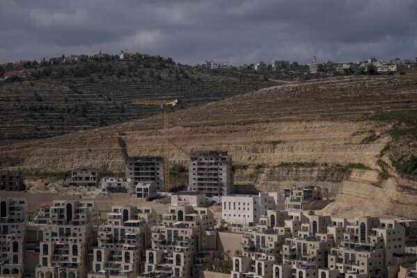 FILE - This photo shows a construction site of new housing projects in the West Bank Israeli settlement of Givat Ze'ev, Monday, June 18, 2023. The population of Israeli settlers in the occupied West Bank grew nearly 3% in 2023, according to a new report based on population statistics from the Israeli government. The report, released Sunday Feb. 11, 2024 by the pro-settler group WestBankJewishPopulationStats.com, found the settler population jumped to 517,407 as of Dec. 31, from 502,991 a year earlier. (AP Photo/Ohad Zwigenberg, File)