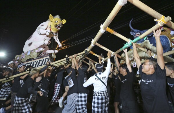 People carry an effigy during Ogoh-ogoh parade, as part of the Balinese Hindu New Year celebrations, in Bali, Indonesia on Sunday, March 10, 2024. The noisy "ogoh-ogoh" processions feature giant scary figures that symbolize evil spirits and are burned in a ritualistic purification, signifying the victory of good over evil.(AP Photo/Firdia Lisnawati)