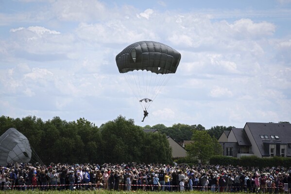 FILE - People attend a multinational parachute drop to commemorate the contribution of airborne forces on D-Day as part of the 80th anniversary of D-Day, in Sannerville, Normandy, France, June 5, 2024. A contingent of U.S. lawmakers from the House of Representatives is also preparing for a commemorative parachute jump at Normandy on Friday, June 6. Organized by Rep. Mike Waltz, R-Fla., and Rep. Jason Crow, D-Colo., the bipartisan group is expected to include 10 congressmen, all veterans themselves (AP Photo/Laurent Cipriani, File)