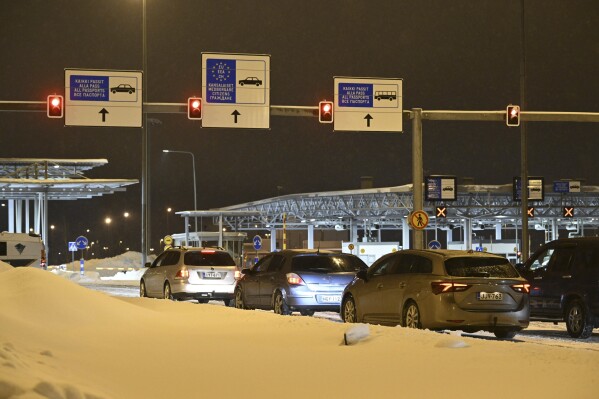 Cars in line wait for the closed Vaalimaa border check point between Finland and Russia to re-open in Virolahti, Finland, Wednesday, Dec. 13, 2023. Two eastern checkpoints, Niirala and Vaalimaa, will be re-opened after Finland closed two weeks ago all checkpoints on border with Russia because of flow of third country migrants via Russia. In Vaalimaa, in the southeast of the country, traffic can cross the border starting midnight on Wednesday. (Heikki Saukkomaa/Lehtikuva via AP)