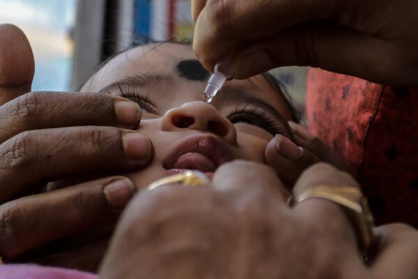 A child is administered polio vaccine at a booth in Kolkata, India, Sunday, Nov. 22, 2020. India's total number of coronavirus cases since the pandemic began has crossed 9 million. (AP Photo/Bikas Das)