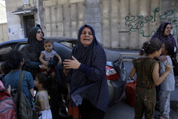 Palestinians rush to the street following Israeli airstrikes on Gaza City, central Gaza Strip, Sunday, Oct. 15, 2023. (AP Photo/Abed Khaled)