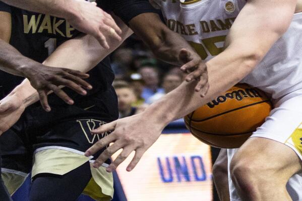 Notre Dame's Matt Zona (25) and Wake Forest's Tyree Appleby (1) fight for a loose ball during the second half of an NCAA college basketball game, Saturday, Feb. 4, 2023, in South Bend, Ind. (AP Photo/Michael Caterina)