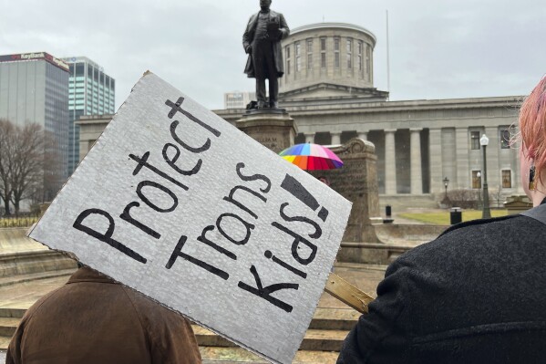 Protesters advocating for transgender rights and healthcare stand outside of the Ohio Statehouse on Wednesday, Jan. 24, 2024, in Columbus, Ohio. (AP Photo/Patrick Orsagos, file)