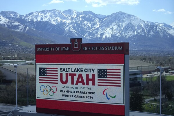 The scoreboard at the University of Utah's Rice-Eccles Stadium promotes Salt Lake City's bid to host another Winter Olympics in 2034 as International Olympic Committee members prepare to tour the stadium and other venues Wednesday, April 10, 2024, in Salt Lake City. (AP Photo/Rick Bowmer)