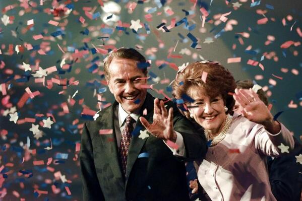 FILE - Bob Dole and his wife Elizabeth wave from the podium on the floor of the Republican National Convention in San Diego,  Aug. 15, 1996, as confetti falls after Dole accepted the Republican presidential nomination. Bob Dole, who overcame disabling war wounds to become a sharp-tongued Senate leader from Kansas, a Republican presidential candidate and then a symbol and celebrant of his dwindling generation of World War II veterans, has died. He was 98. His wife, Elizabeth Dole, posted the announcement Sunday on Twitter (AP Photo/J. Scott Applewhite, File)