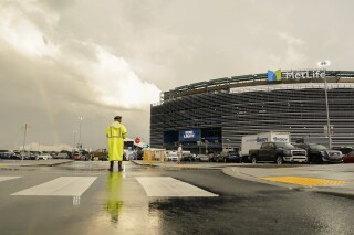 A parking attendant views a rainbow outside Met Life stadium before an NFL football game between the New York Jets and the Buffalo Bills, Monday, Sept. 11, 2023, in East Rutherford, N.J. (AP Photo/Seth Wenig)