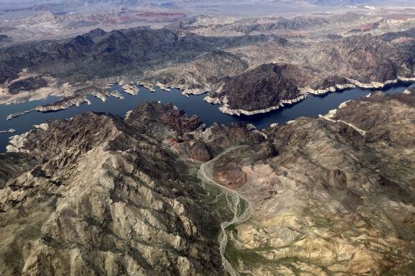 FILE - In this aerial photo, a bathtub ring of light minerals show the high water mark on the shore of Lake Mead along the border of Nevada and Arizona, Monday, March 6, 2023, near Boulder City, Nev. The federal government is expected to make an announcement on Tuesday, Aug. 15, 2023, about the health of the Colorado River and water cuts in 2024. (AP Photo/John Locher,File)