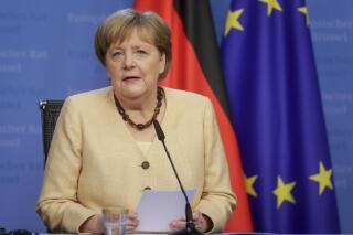 FILE - In this Friday, June 25, 2021 file photo German Chancellor Angela Merkel talks to journalists during a news conference at the end of an EU summit at the European Council building in Brussels, Belgium. Angela Merkel on Monday defended a plan to resume official European Union meetings with Russian President Vladimir Putin that was rejected last week by eastern EU members, arguing that it would offer an opportunity to confront Putin with European concerns. (Stephanie Lecocq, Pool Photo via AP, file)