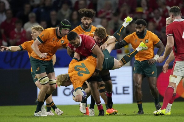 Wales' Taulupe Faletau tackles Australia's Carter Gordon during the Rugby World Cup Pool C match between Wales and Australia at the OL Stadium in Lyon, France, Sunday, Sept. 24, 2023. (AP Photo/Christophe Ena)