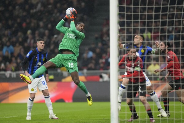 AC Milan's goalkeeper Mike Maignan, top, catches the ball during a Serie A soccer match between AC Milan and Inter Milan at the San Siro stadium in Milan, Italy, Monday, April 22, 2024. (AP Photo/Luca Bruno)