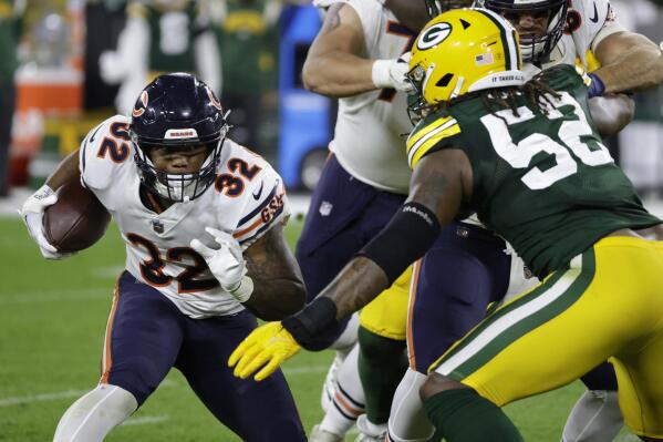 Chicago Bears running back David Montgomery (32) runs from Green Bay Packers linebacker Rashan Gary (52) during the second half of an NFL football game Sunday, Sept. 18, 2022, in Green Bay, Wis. (AP Photo/Mike Roemer)