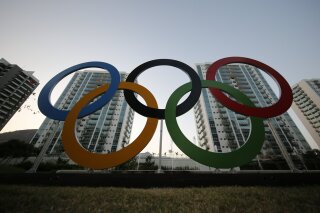 FILE - In this July 23, 2016, file photo, a representation of the Olympic rings are displayed in the Olympic Village in Rio de Janeiro, Brazil. An eye-opening survey finds that the majority of elite and Olympic athletes struggle to make ends meet. 58 percent of the 491 respondents from across the globe said they did not consider themselves financially stable. (AP Photo/Leo Correa, File)