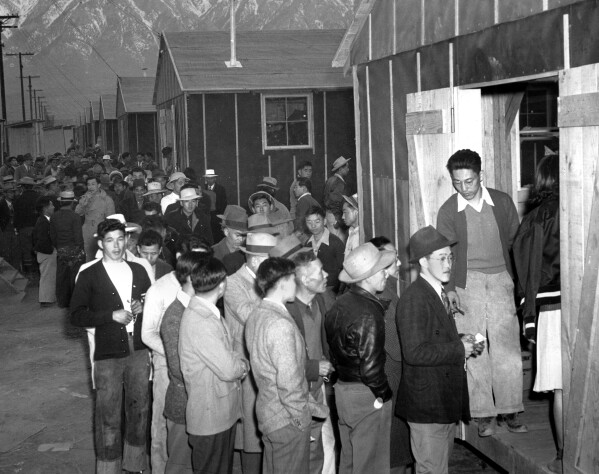  In this March 24, 1942 file photo Japanese citizens wait in line for their assigned homes at an alien reception center in Manzanar, Calif.  Many were forced from their homes in Los Angeles by the U.S. Army. (AP Photo, file)