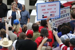 Shelley Luther, owner of Salon Á la Mode in Dallas speaks to the crowd during the Set Texas Free Rally at Dealey Plaza in Dallas, on Saturday, May 9, 2020. (Vernon Bryant /The Dallas Morning News via AP)