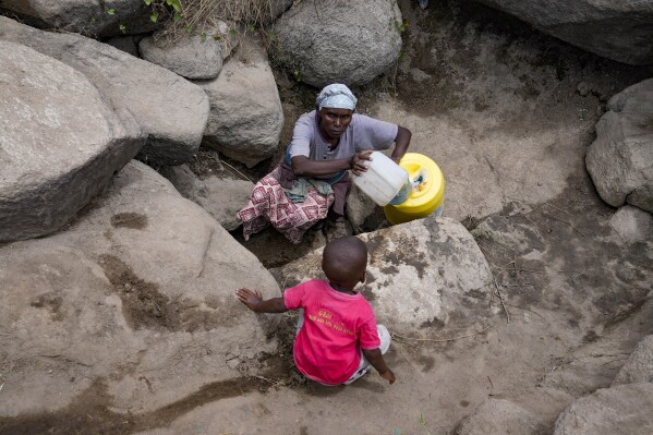 Joyce Ngui fetches groundwater in Athi River, Machakos county, Kenya, Tuesday, Oct. 17, 2023. “Sometimes, we get to the water vending stations and find that the queue is long and then the water finishes and you have to wait,” Ngui said. “Most of the times you don’t have money to buy even the salty water sold around. So we have no choice but to use the swamp water," she said. (AP Photo/Brian Inganga)