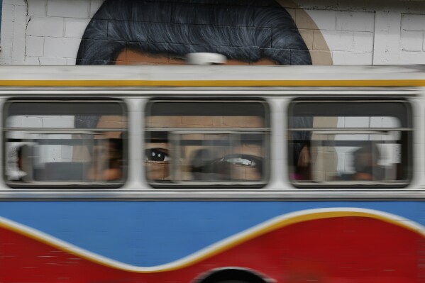 Un autobús de la red de transporte público pasa por delante de un mural con el rostro del presidente de Venezuela, Nicolás Maduro, en Caracas, Venezuela, el 5 de junio de 2025. (AP Foto/Ariana Cubillos)