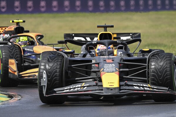 Red Bull Racing driver Max Verstappen of the Netherlands, front, holds off a challenge from McLaren driver Lando Norris, of the United Kingdom, as he drives through the Senna corner at the Formula 1 Canadian Grand Prix auto race in Montreal, Sunday, June 9, 2024. (Graham Hughes/The Canadian Press via AP)