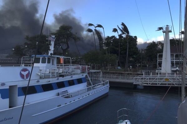Nesta foto fornecida por Brandin Stevens, a fumaça enche o ar de um incêndio florestal no porto de Lahaina na terça-feira, 8 de agosto de 2023, no Havaí.  O incêndio se espalhou pela cidade de Lahaina, incluindo Front Street, uma área popular de compras e restaurantes, disse a porta-voz do condado de Maui, Mahina Martin, por telefone na quarta-feira.  O tráfego está intenso enquanto as pessoas tentam evacuar a área, e as autoridades pediram às pessoas que não estão na zona de evacuação que fiquem lá para evitar engarrafamentos, disse ele.  (Por Brandin Stevens via AP)