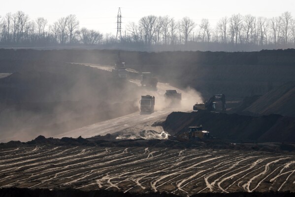 Mining haul trucks operate in an ilmenite open pit mine in a canyon in the central region of Kirovohrad, Ukraine, Wednesday, Feb. 12, 2025. (AP Photo/Efrem Lukatsky)