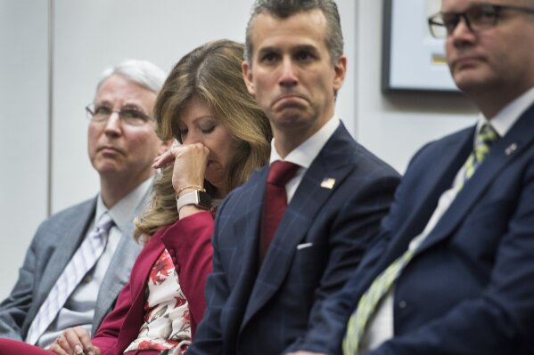 Susan Payne, founder and executive director of Safe2Tell wipes tears, as Peter Langman, left, Max Schachter, who lost his son Alex during the Parkland school mass shooting, center, and Ryan Petty, right, who lost his daughter Alaina during the Parkland school mass shooting, appear at the the release of the Secret Service National Threat Assessment Center's Protecting America's Schools report, in Washington, Thursday, Nov. 7, 2019. The report examines 41-targeted attacks that occurred in schools between 2008 and 2017. (AP Photo/Cliff Owen)