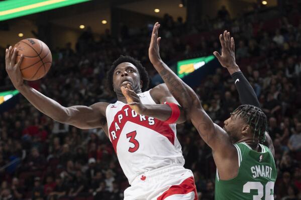 Toronto Raptors' O.G. Anunoby (3) shoots around Boston Celtics' Marcus Smart during second-half NBA preseason basketball game action in Montreal, Friday, Oct. 14, 2022. (Graham Hughes/The Canadian Press via AP)