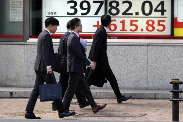 People walk in front of an electronic stock board showing Japan's Nikkei 225 index at a securities firm Friday, March 1, 2024, in Tokyo. Asian stocks gained Friday, after U.S. stocks climbed to all-time highs Thursday. (APPhoto/Eugene Hoshiko)