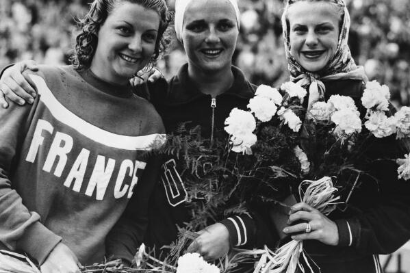 File - From left to right, Madeleine Moreau, of France (silver medallist, 139.34 points); Patricia McCormick, of the United States (gold, 147.30 points); and United States' Zoe Jensen (bronze, 127.57 points), spose after the women's 3-meter springboard diving event at the Summer Olympics Games in Helsinki, Finland, on July 30, 1952. McCormick died Tuesday, March 7, 2023, in Santa Ana, Calif., at age 92, according to her son, Tim McCormick. (AP Photo/Pool, File)