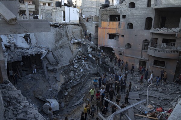 Palestinians search for survivors from a building destroyed in Israeli bombardment in Khan Younis, Gaza Strip, Thursday, Oct. 19, 2023. (AP Photo/Fatima Shbair)