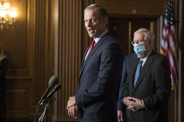 Senate Majority Leader Mitch McConnell of Ky., listens as Sen. John Thune, R-S.D., speaks during a news conference with other Senate Republicans on Capitol Hill in Washington, Tuesday, Dec. 15, 2020. (Rod Lamkey/Pool via AP)