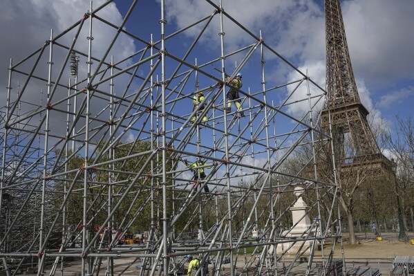 Workers build constructions on the Champ-de-Mars, near the Eiffel Tower, ahead of the Paris 2024 Olympic Games, Wednesday, April 10, 2024 in Paris. (AP Photo/Laurent Cipriani, File)