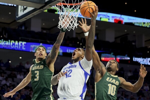 Memphis forward Dain Dainja (42) scores between UAB forward Yaxel Lendeborg (3) and guard Alejandro Vasquez (10) during the second half of an NCAA college basketball game in the championship of the American Athletic Conference tournament, Sunday, March 16, 2025, in Fort Worth, Texas. (AP Photo/Gareth Patterson)
