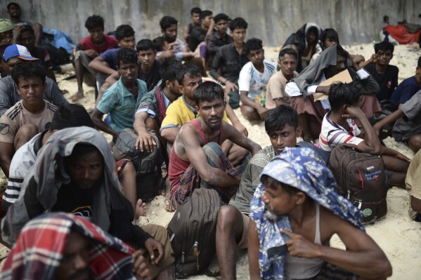 FILE - Ethnic Rohingya men sit on a beach after they landed in Sabang, Aceh province, Indonesia, Wednesday, Nov. 22, 2023. The U.N. refugee agency on Monday Dec. 4, 2023 sounded the alarm for hundreds of Rohingya Muslims believed to be aboard two boats reported to be out of supplies and adrift on the Andaman Sea. (APPhoto/Reza Saifullah, File)