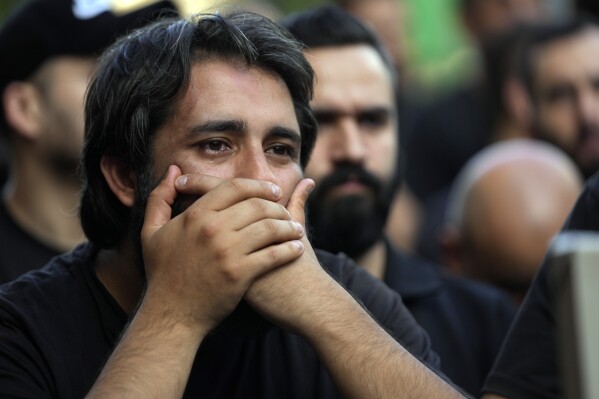 A man mourns during the funeral procession of two Hezbollah members, killed on Wednesday when a handheld device exploded, in the southern suburbs of Beirut, Thursday, Sept. 19, 2024. (AP Photo/Hussein Malla)