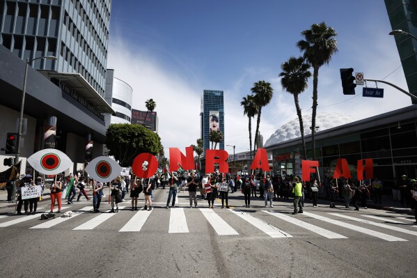 Protesters line up holding letters and symbols reading "Eyes on Rafah," during a demonstration in support of Palestinians calling for a ceasefire in Gaza as the 96th Academy Awards Oscars ceremony is held nearby, Sunday, March 10, 2024, in the Hollywood section of Los Angeles. (AP Photo/Etienne Laurent)