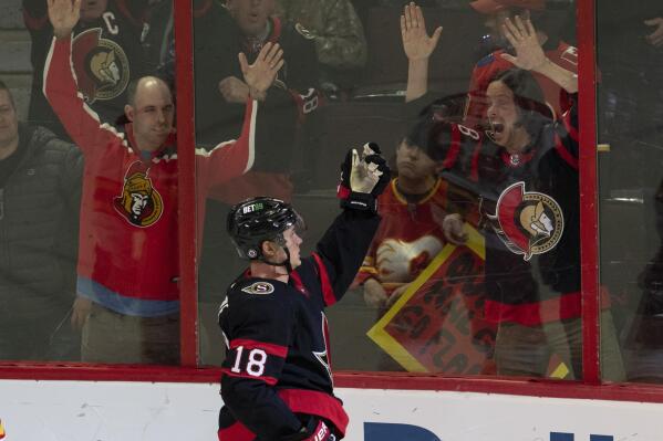 Fans react as Ottawa Senators left wing Tim Stutzle (18) celebrates after his winning goal in overtime of an HHL hockey game against the Calgary Flames, Monday, Feb. 13, 2023, in Ottawa, Ontario. (Adrian Wyld/The Canadian Press via AP)