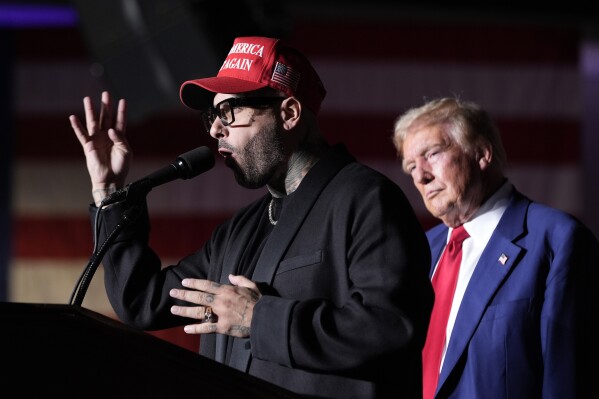 Nicky Jam speaks as Republican presidential nominee former President Donald Trump listens during a campaign event at the World Market Center, Friday, Sept.13, 2024, in Las Vegas. (AP Photo/Alex Brandon)