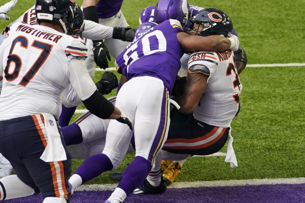 Chicago Bears running back David Montgomery, right, scores on a 1-yard touchdown run ahead of Minnesota Vikings linebacker Eric Wilson (50) during the first half of an NFL football game, Sunday, Dec. 20, 2020, in Minneapolis. (AP Photo/Jim Mone)