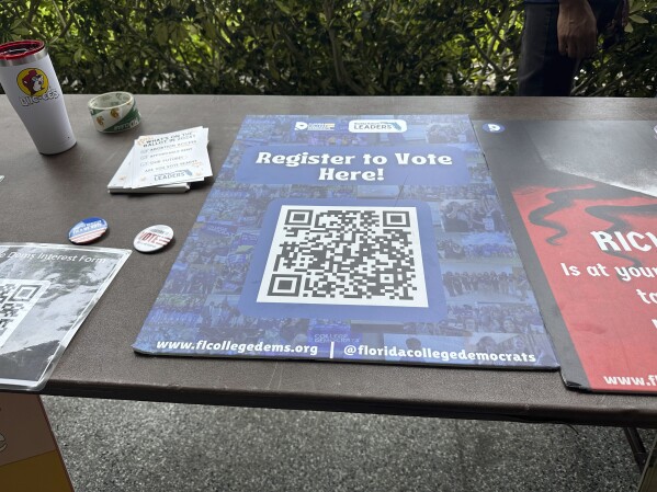 A QR code sign is displayed at Florida Atlantic University on Thursday, April 11, 2024, in Boca Raton, Fla. for students to register to vote. Abortion and marijuana will be on Florida's November ballot, and these issues are critical issues for young voters. (AP Photo/Cody Jackson)