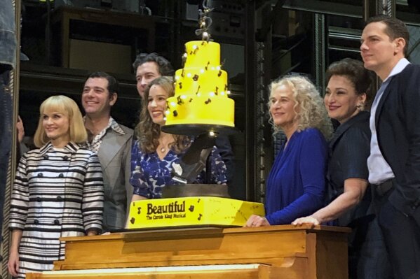 
              In this Saturday, Jan. 12, 2019, photo Carole King, third from right, poses for photos with the cast of “Beautiful: The Carole King Musical” at the Stephen Sondheim Theatre after a performance in New York. King appeared Saturday night, sitting at a baby grand piano and showing all the love in her heart as she sang "Beautiful," the final song to celebrate the show's fifth anniversary on Broadway. (AP Photo/Brooke Lefferts)
            