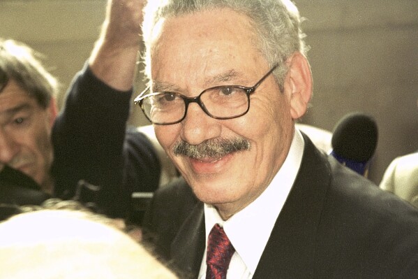 FILE - Former Algerian Defense Minister and retired Gen. Khaled Nezzar smiles as he answers reporters at the Paris courthouse Monday, July 1, 2002. Swiss federal prosecutors said Tuesday they have indicted a former Algerian defense minister, now aged 85 and reportedly “on his deathbed,” for his alleged role in crimes against humanity during the North African country’s insurrection some three decades ago. (AP Photo/Amel Pain, File)