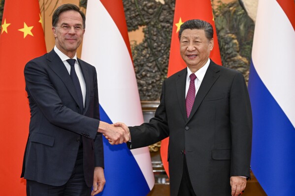 In this photo released by Xinhua News Agency, Chinese President Xi Jinping, right, shakes hands with Dutch Prime Minister Mark Rutte at the Great Hall of the People in Beijing on Wednesday, March 27, 2024. Chinese leader Xi Jinping has told visiting Dutch Prime Minister Mark Rutte that attempts to restrict China's access to technology will not stop the country's advance. (Li Xueren/Xinhua via AP)