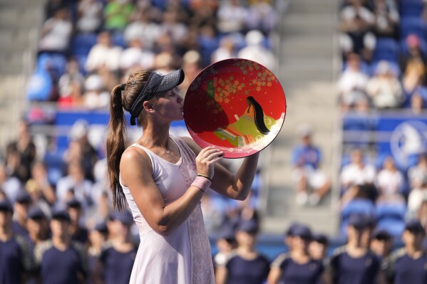 Veronika Kudermetova of Russia kisses her champion trophy during the award ceremony for the singles after defeating Jessica Pegula of the U.S. in the Pan Pacific Open tennis tournament in Tokyo, Sunday, Oct. 1, 2023. (AP Photo/Hiro Komae)