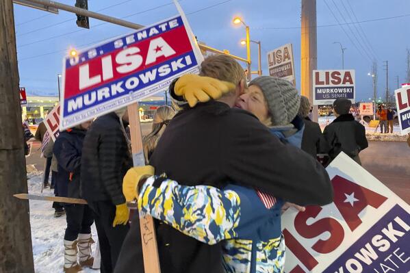 United States Sen. Lisa Murkowski, right, a Republican seeking reelection in Alaska, hugs her nephew, Luke Murkowski who flew in from Nome, Alaska, to surprise her at a sign-waving event on a busy Anchorage, Alaska, corner on Election Day, Tuesday, Nov. 8, 2022. Lisa Murkowski faces Republican Kelly Tshibaka and Democrat Pat Chesbro in the general election. (AP Photo/Mark Thiessen)